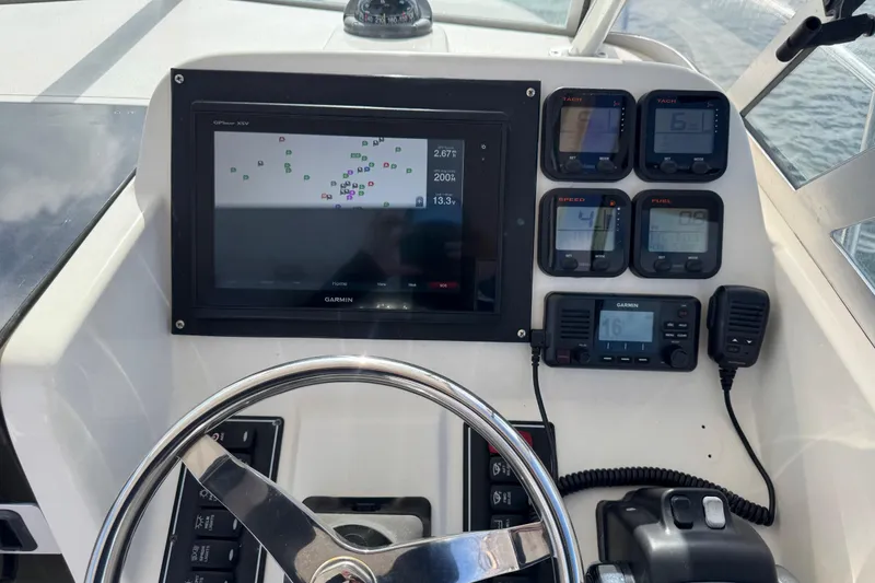 Slide: The Image of Dashboard of a 2007 Pursuit OS 255 Offshore boat with navigation and control instruments. - 6