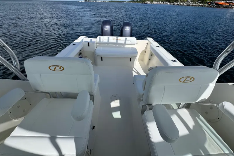Slide: The Image of 2007 Pursuit OS 255 Offshore boat interior with white seating and dual engines. - 7