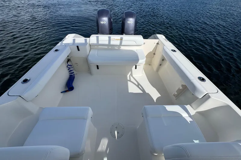 Slide: The Image of 2007 Pursuit OS 255 Offshore boat interior with seating and twin engines on water. - 8