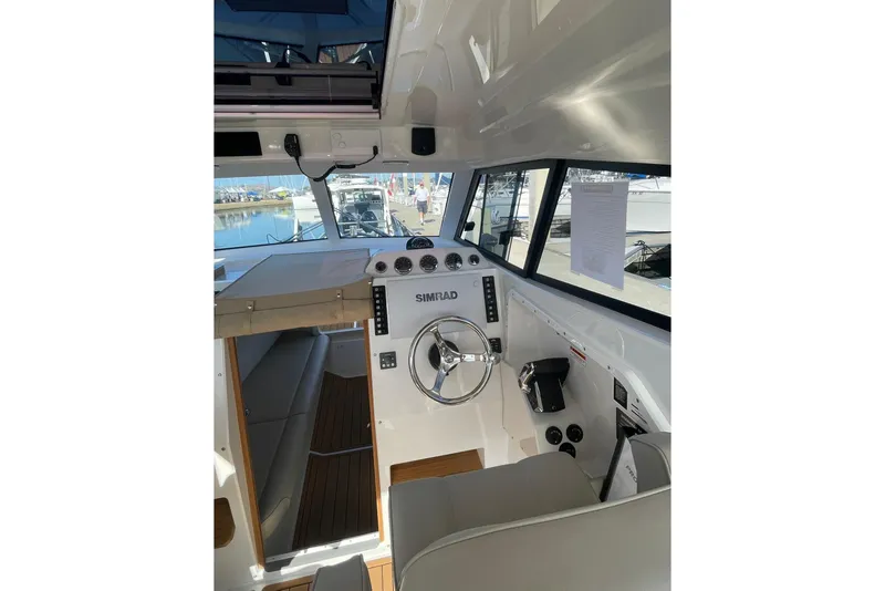 Slide: The Image of Interior view of 2024 Protector 330 Targa boat, featuring modern controls and steering wheel. - 10