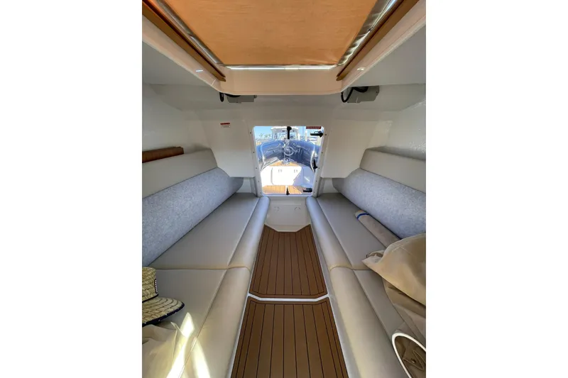 Slide: The Image of 2024 Protector 330 Targa cabin interior with seating and wood flooring. - 12