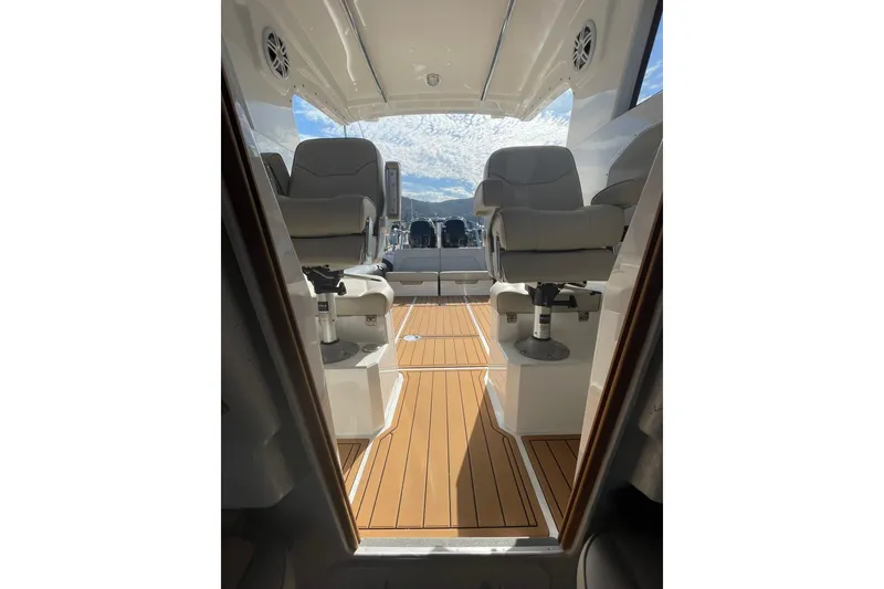 Slide: The Image of 2024 Protector 330 Targa boat interior with twin 400 HP engines, featuring sleek seating and wood flooring. - 15