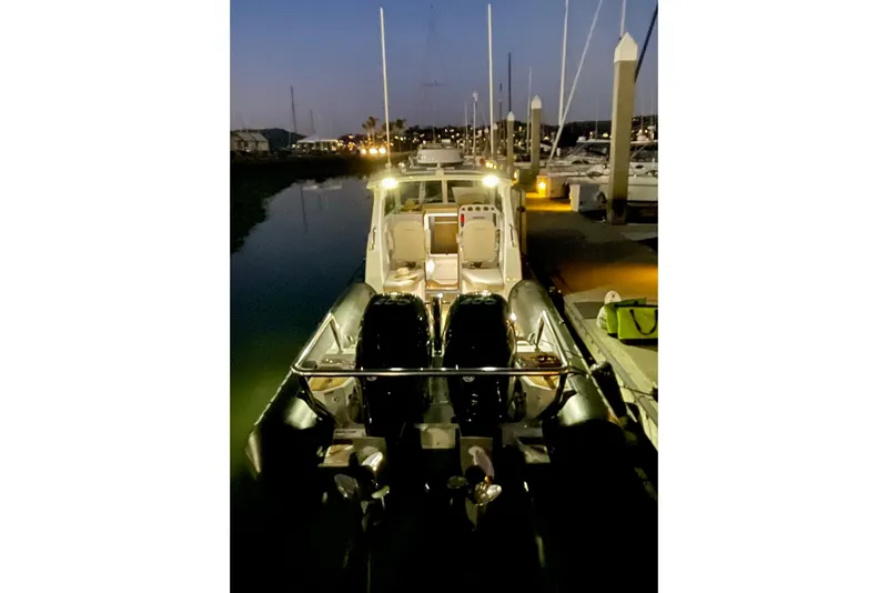 Slide: The Image of 2024 Protector 330 Targa boat with twin 400 HP engines docked at night. - 19