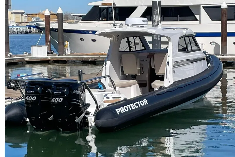 Slide: The Image of 2024 Protector 330 Targa boat with twin 400 HP engines docked in marina. - 3