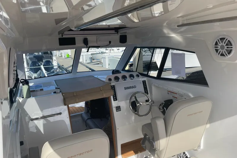 Slide: The Image of Interior of 2024 Protector 330 Targa boat with modern controls and seating. - 8