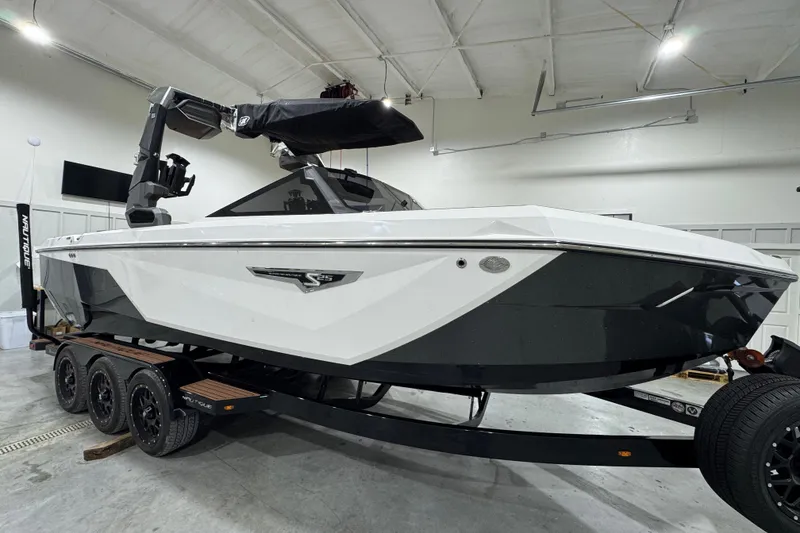 Slide: The Image of 2023 Nautique Super Air Nautique S25 boat, rear view in showroom setting. - 10