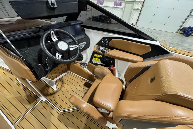 Slide: The Image of 2023 Nautique Super Air Nautique S25 interior with tan seating and sleek design. - 11