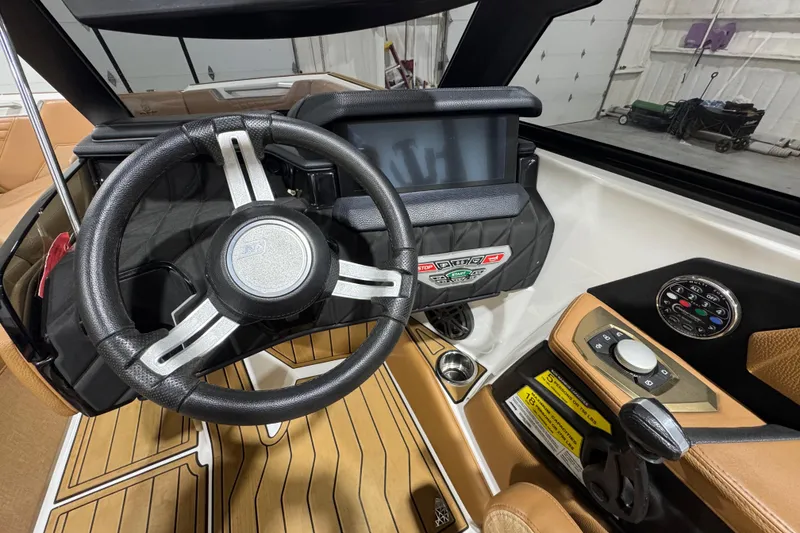 Slide: The Image of 2023 Nautique Super Air Nautique S25 boat interior with tan seating and cup holders. - 12