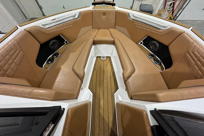Slide: The Image of 2023 Nautique Super Air Nautique S25 interior with tan seating and teak flooring. - 13