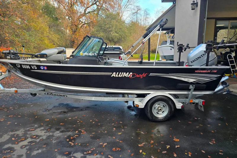 Slide: The Image of 2020 Alumacraft Voyageur 175 Sport boat on trailer, parked outdoors with autumn leaves. - 12