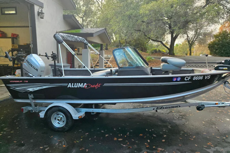 Slide: The Image of 2020 Alumacraft Voyageur 175 Sport boat on trailer, parked outdoors. - 13
