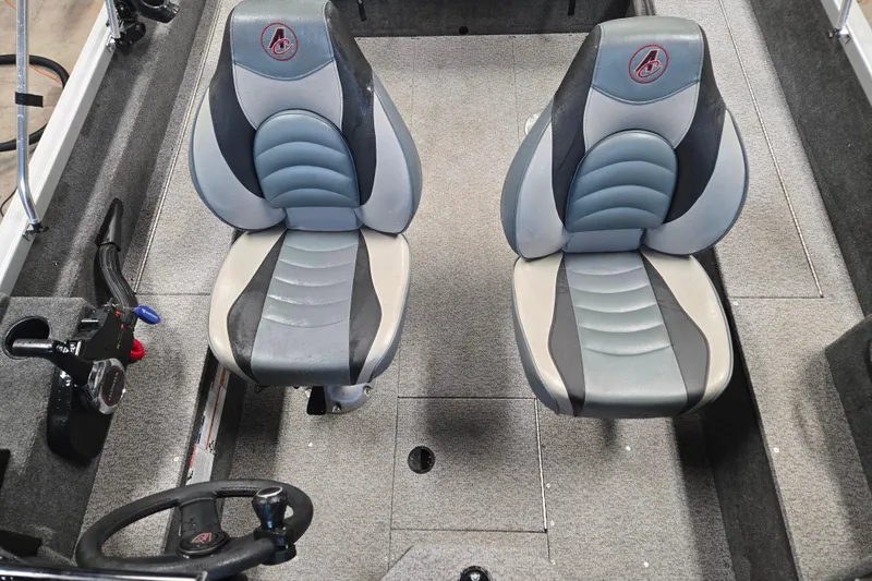 Slide: The Image of 2020 Alumacraft Voyageur 175 Sport interior with two cushioned seats and steering wheel. - 18