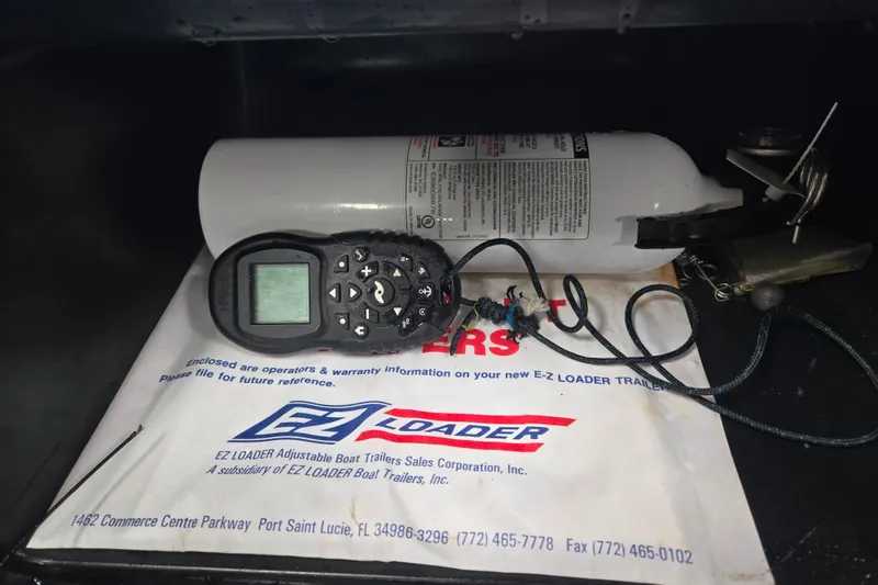 Slide: The Image of Storage compartment of 2020 Alumacraft Voyageur 175 Sport with fire extinguisher and remote control. - 8