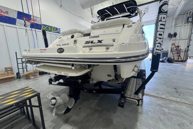 Slide: The Image of 2015 Sea Ray 250 SLX boat in a garage, rear view with propeller visible. - 3