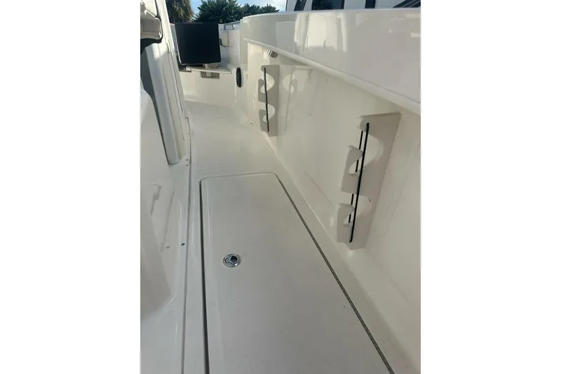 Slide: The Image of 2024 Bayliner Trophy T24CC boat deck with rod holders and storage compartment. - 13