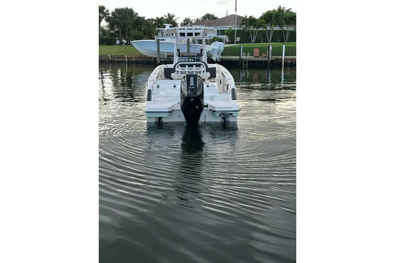 Slide: The Image of 2024 Bayliner Trophy T24CC boat on calm water, rear view. - 22