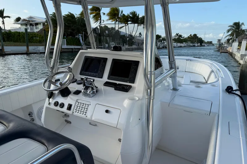 Slide: The Image of 2013 Intrepid 327 Cuddy boat interior with steering wheel and navigation screens. - 2
