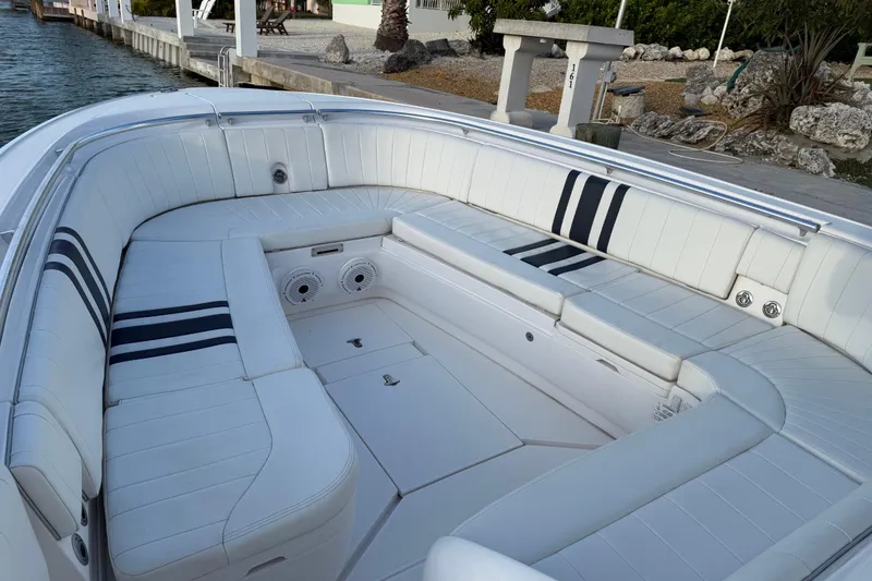 Slide: The Image of Luxurious seating area on a 2013 Intrepid 327 Cuddy boat, featuring white upholstery. - 3