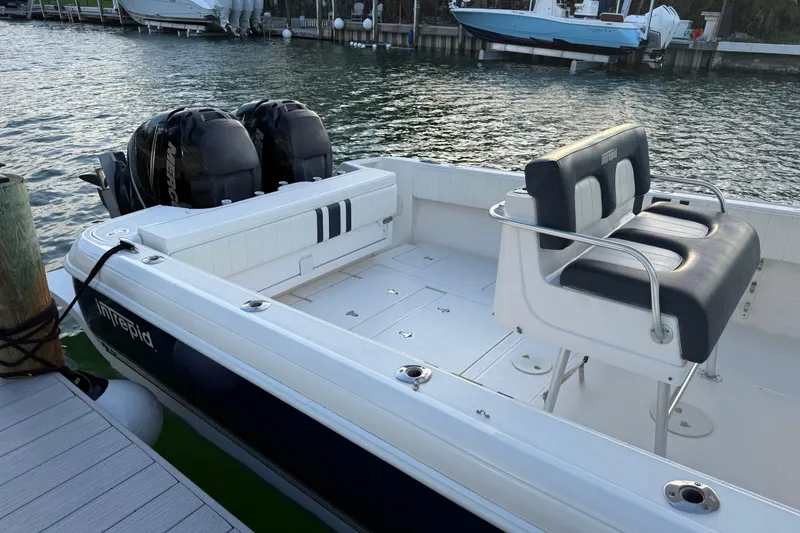 Slide: The Image of 2013 Intrepid 327 Cuddy boat docked, featuring dual engines and spacious seating. - 6