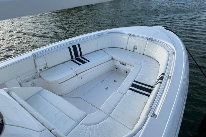 Slide: The Image of 2013 Intrepid 327 Cuddy boat with white seating, docked on calm water. - 7