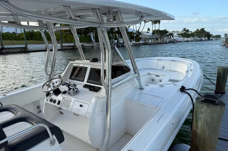 Slide: The Image of 2013 Intrepid 327 Cuddy boat docked, featuring sleek design and modern controls. - 8
