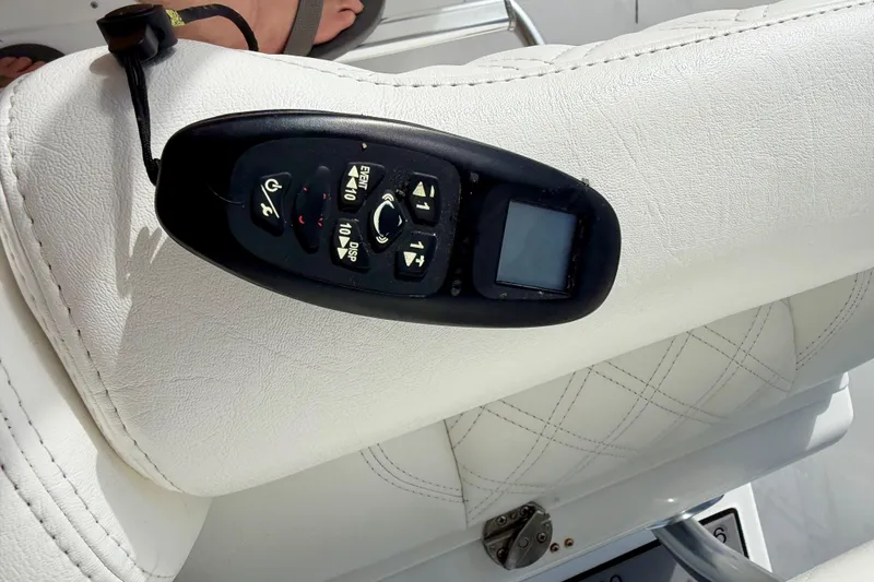 Slide: The Image of Control panel on white leather seat of 2025 Ocean Master 296 Center Console boat. - 13