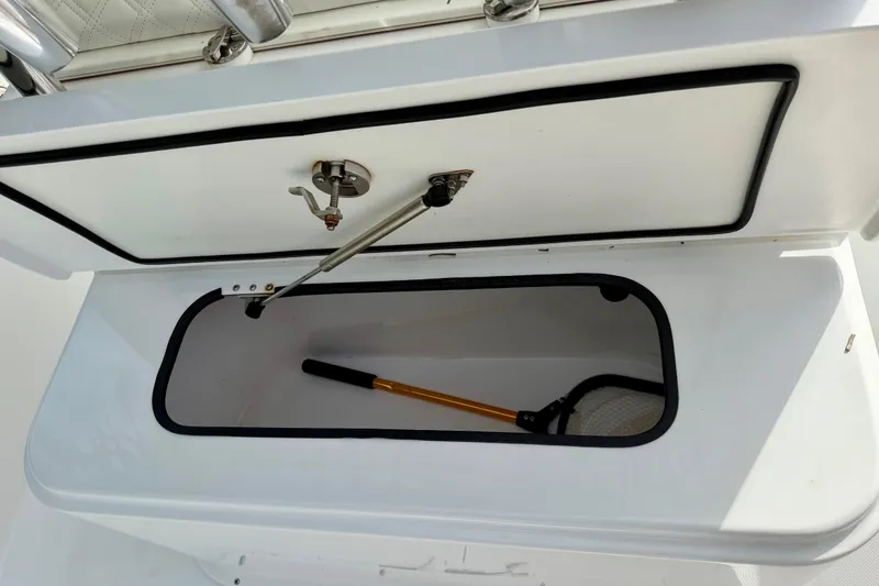 Slide: The Image of Storage compartment on 2025 Ocean Master 296 Center Console boat, featuring a fishing net. - 21