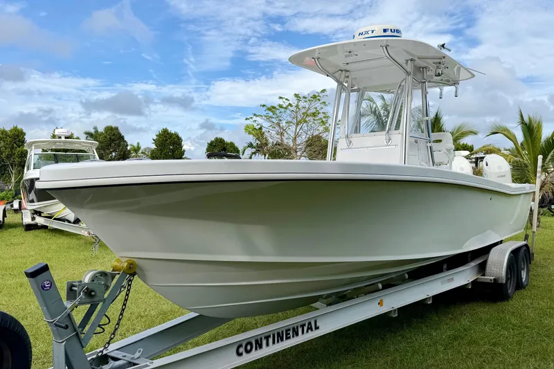 The Image of 2025 Ocean Master 296 Center Console boat on trailer, set against a clear blue sky. - 1