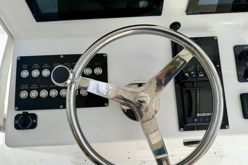 Slide: The Image of Steering wheel and controls of 2025 Ocean Master 296 Center Console boat. - 14