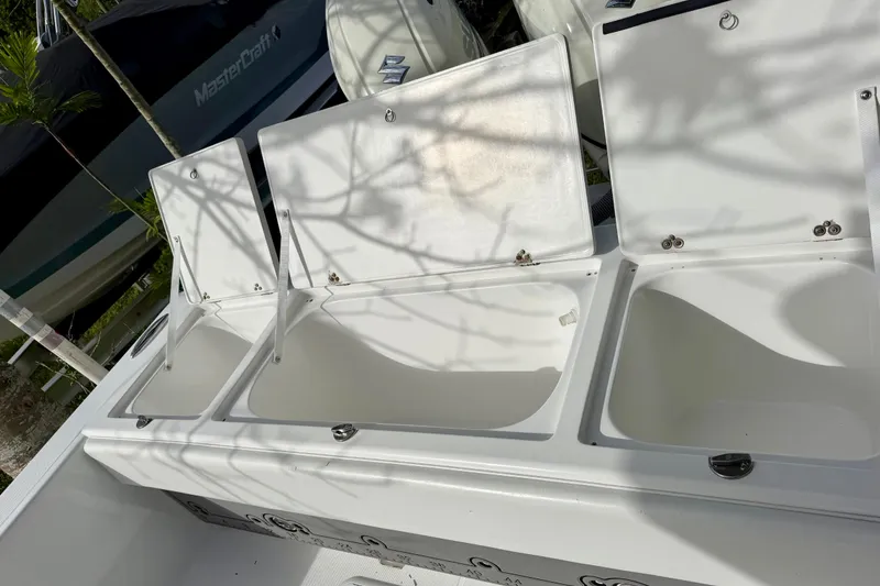 Slide: The Image of Open storage compartments on a 2025 Ocean Master 296 Center Console boat. - 17