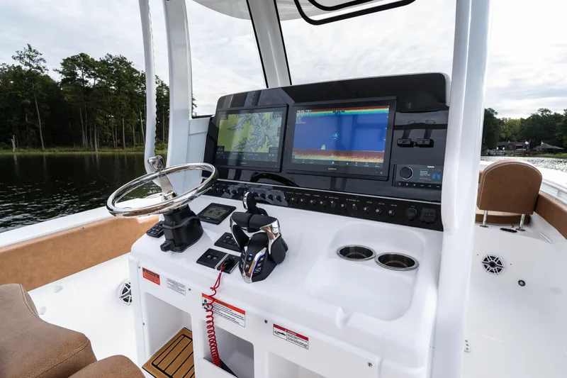 The Image of 2026 Sea Hunt Ultra 285 SE boat dashboard with navigation screens and steering wheel. - 0