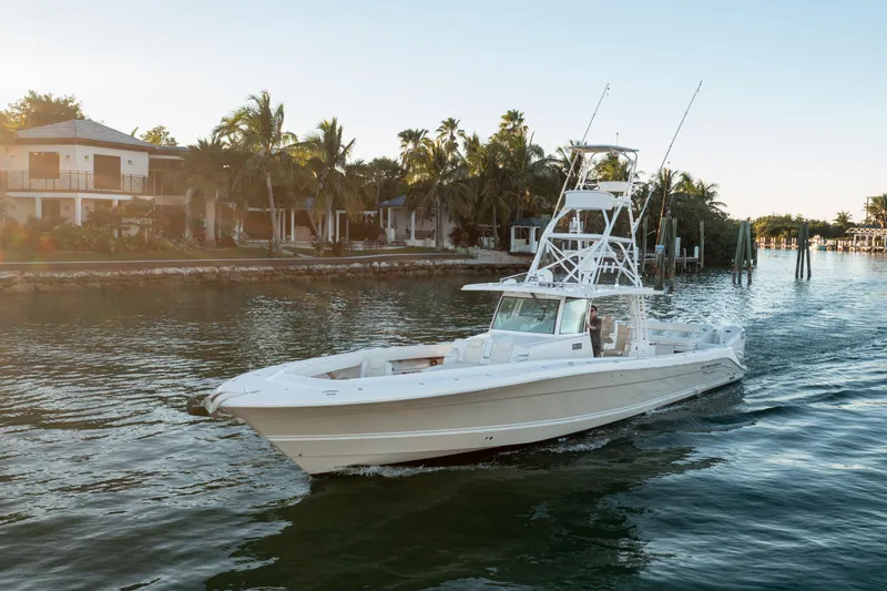 Slide: The Image of 2018 HCB 53 Suenos RXV boat cruising near waterfront homes and palm trees. - 18