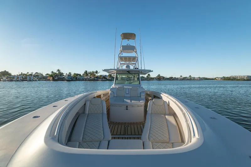 Slide: The Image of 2018 HCB 53 Suenos RXV luxury boat on calm water, featuring spacious seating and clear skies. - 44