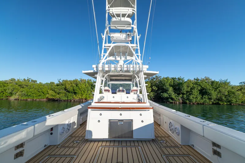 Slide: The Image of 2018 HCB 53 Suenos RXV boat with spacious deck and tower, surrounded by lush greenery. - 46