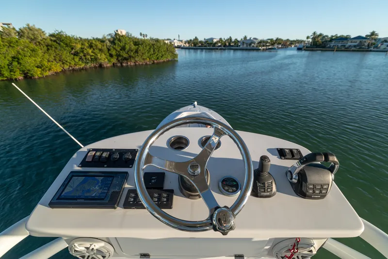 Slide: The Image of Helm of 2018 HCB 53 Suenos RXV boat with navigation controls on calm water. - 54