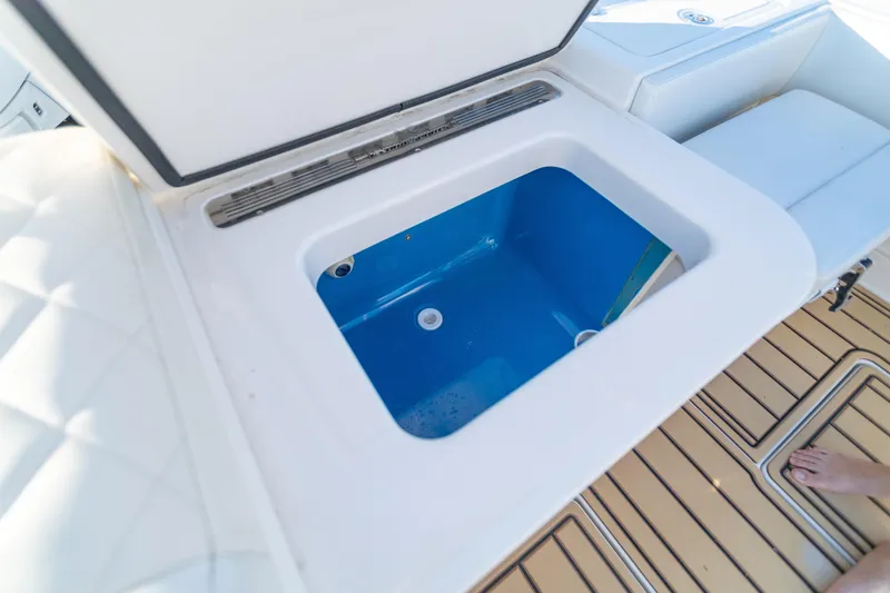 Slide: The Image of Open storage compartment on 2018 HCB 53 Suenos RXV boat, featuring blue interior. - 57