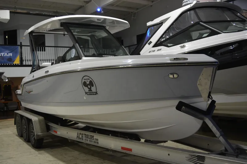 The Image of 2026 Monterey Elite 25 OB boat on trailer in showroom setting. - 0
