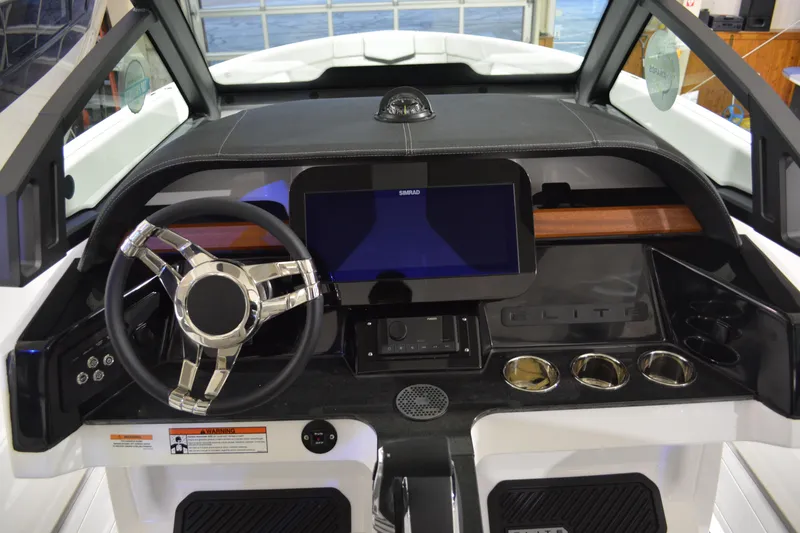 Slide: The Image of 2026 Monterey Elite 25 OB boat dashboard with steering wheel and digital display. - 20