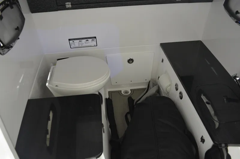 Slide: The Image of Interior of 2026 Monterey Elite 25 OB boat featuring a compact bathroom with toilet. - 33
