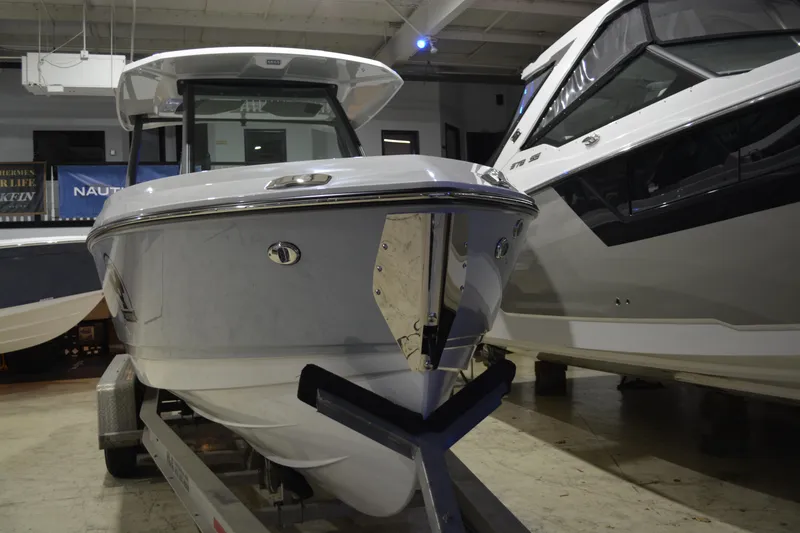 Slide: The Image of 2026 Monterey Elite 25 OB boat displayed indoors on a trailer. - 5