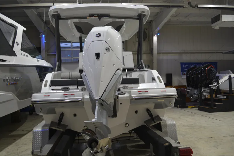 Slide: The Image of 2026 Monterey Elite 25 OB boat in showroom, rear view with outboard motor. - 8