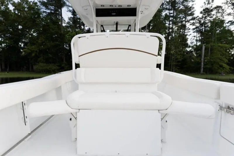 Slide: The Image of Manufacturer Provided Image: 2026 Sea Hunt Ultra 239 SE boat interior with white seating and lush forest backdrop. - 8
