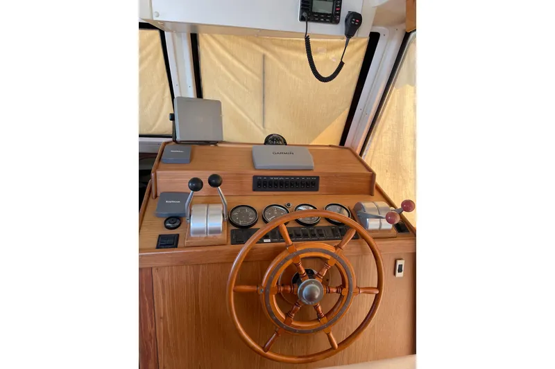 Slide: The Image of 1999 Mainship 430 Trawler helm with wooden wheel and navigation instruments. - 10