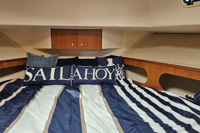 Slide: The Image of Cozy cabin interior of 1999 Mainship 430 Trawler with nautical-themed bedding. - 12