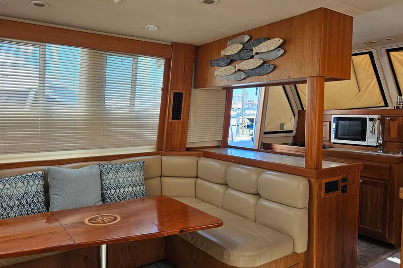 Slide: The Image of Interior of 1999 Mainship 430 Trawler with cozy seating and wooden accents. - 4