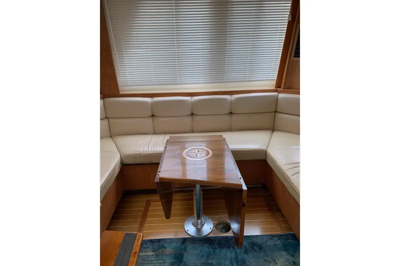 Slide: The Image of Interior of 1999 Mainship 430 Trawler with beige seating and wooden table. - 6