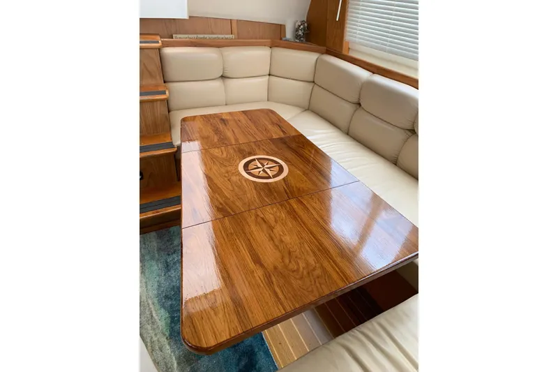 Slide: The Image of Luxurious interior of 1999 Mainship 430 Trawler with elegant wood table and plush seating. - 7