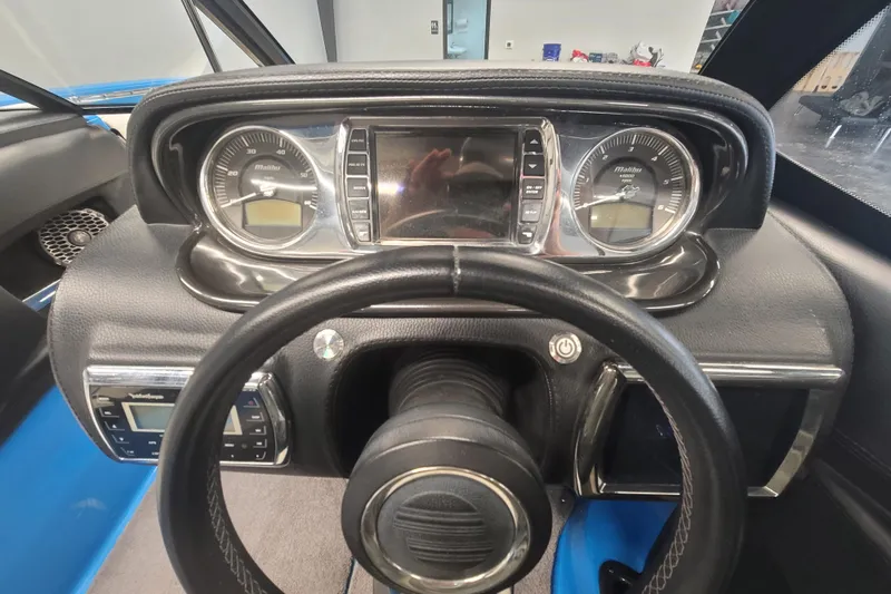 Slide: The Image of Dashboard of a 2014 Malibu Wakesetter 24 MXZ boat with steering wheel and gauges. - 17