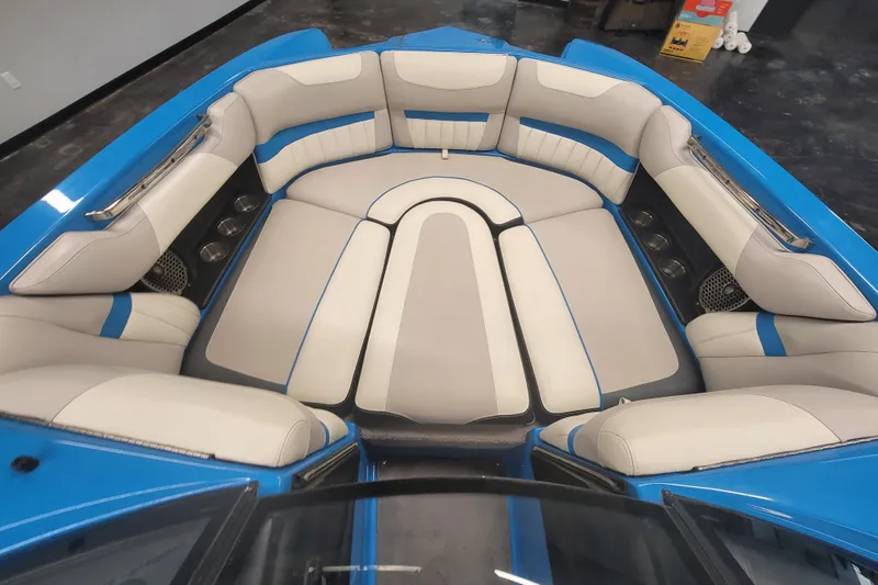Slide: The Image of 2014 Malibu Wakesetter 24 MXZ boat interior with blue and beige seating. - 18