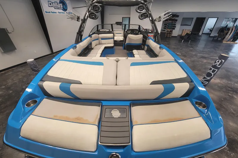 Slide: The Image of 2014 Malibu Wakesetter 24 MXZ boat interior with blue and white seating. - 24